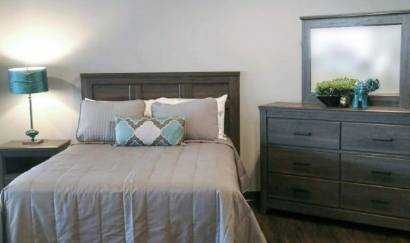 Bedroom setting with bed and dresser with mirror